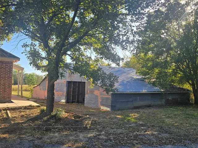 a view of a house with a yard tree and a tree