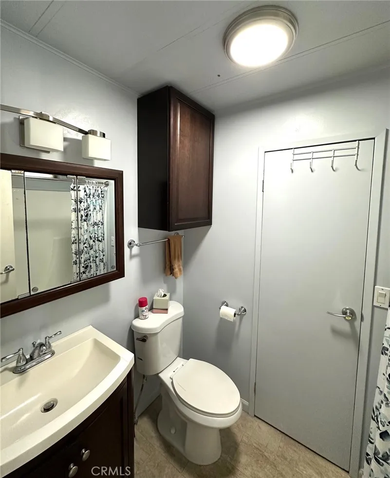 15181 Van Buren, Unit 57 Riverside, CA 92504 - Photo 12 of 38 a bathroom with a sink mirror vanity and toilet