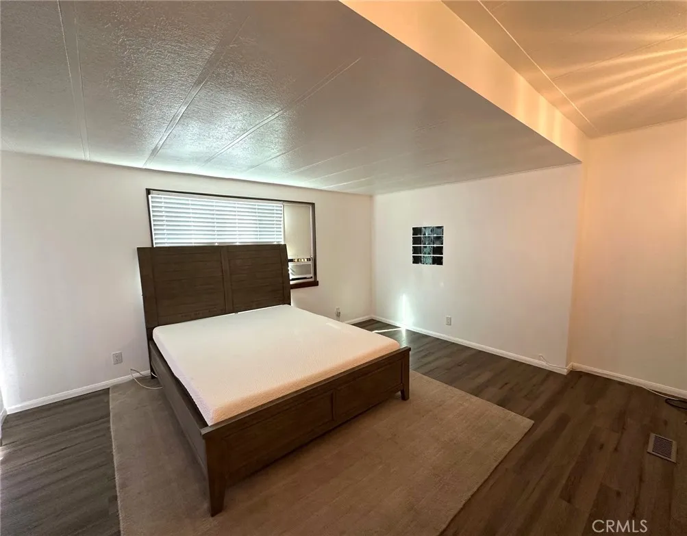 15181 Van Buren, Unit 57 Riverside, CA 92504 - Photo 13 of 38 a bed sitting in a bedroom and wooden floor