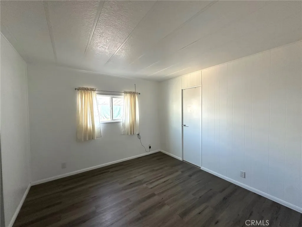 15181 Van Buren, Unit 57 Riverside, CA 92501 - Photo 15 of 38 an empty room with wooden floor and windows