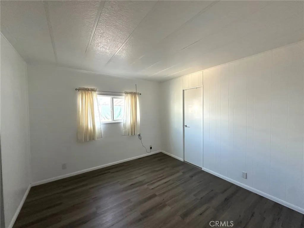 15181 Van Buren, Unit 57 Riverside, CA 92504 - Photo 15 of 38 an empty room with wooden floor and windows