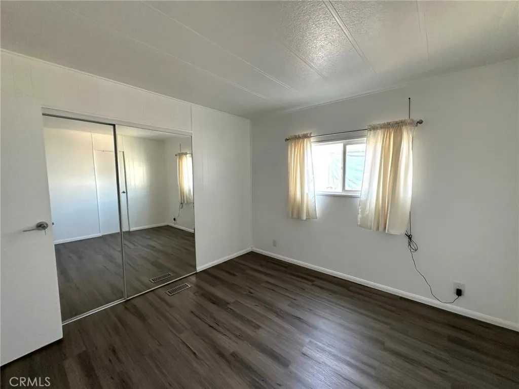 15181 Van Buren, Unit 57 Riverside, CA 92504 - Photo 16 of 38 an empty room with wooden floor and windows