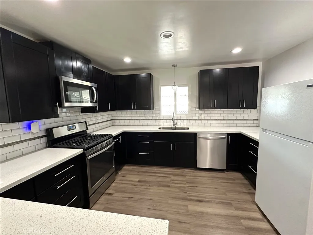 15181 Van Buren, Unit 57 Riverside, CA 92504 - Photo 9 of 38 a large kitchen with a large counter top stainless steel appliances and cabinets