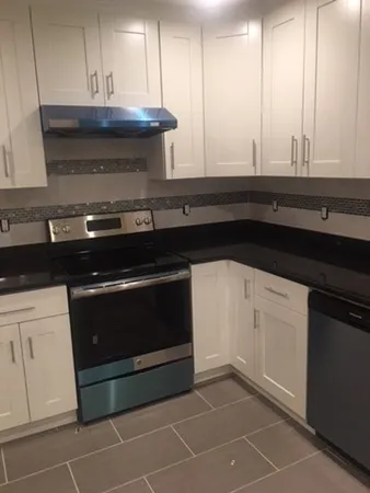 a stove top oven sitting inside of a kitchen