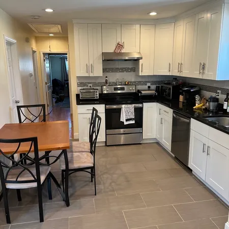 a kitchen with stainless steel appliances granite countertop a stove a sink a refrigerator and a cabinets