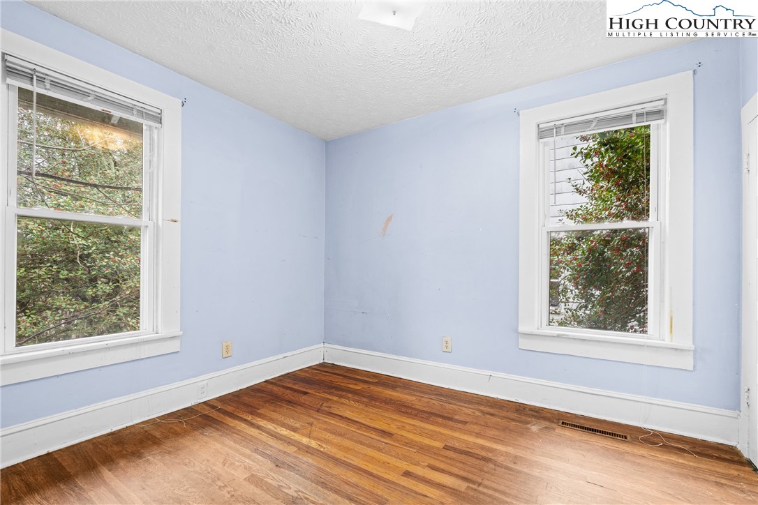 192-206 Orchard Street Boone, NC 28607 - Photo 35 of 50 a view of an empty room with wooden floor and a window