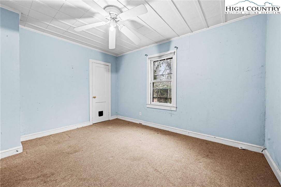 192-206 Orchard Street Boone, NC 28607 - Photo 45 of 50 an empty room with a chandelier fan and windows
