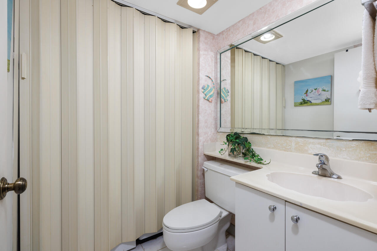5996 Southeast Riverboat Drive, Unit 539 Stuart, FL 34997 - Photo 12 of 29 a bathroom with a sink a toilet and shower curtain