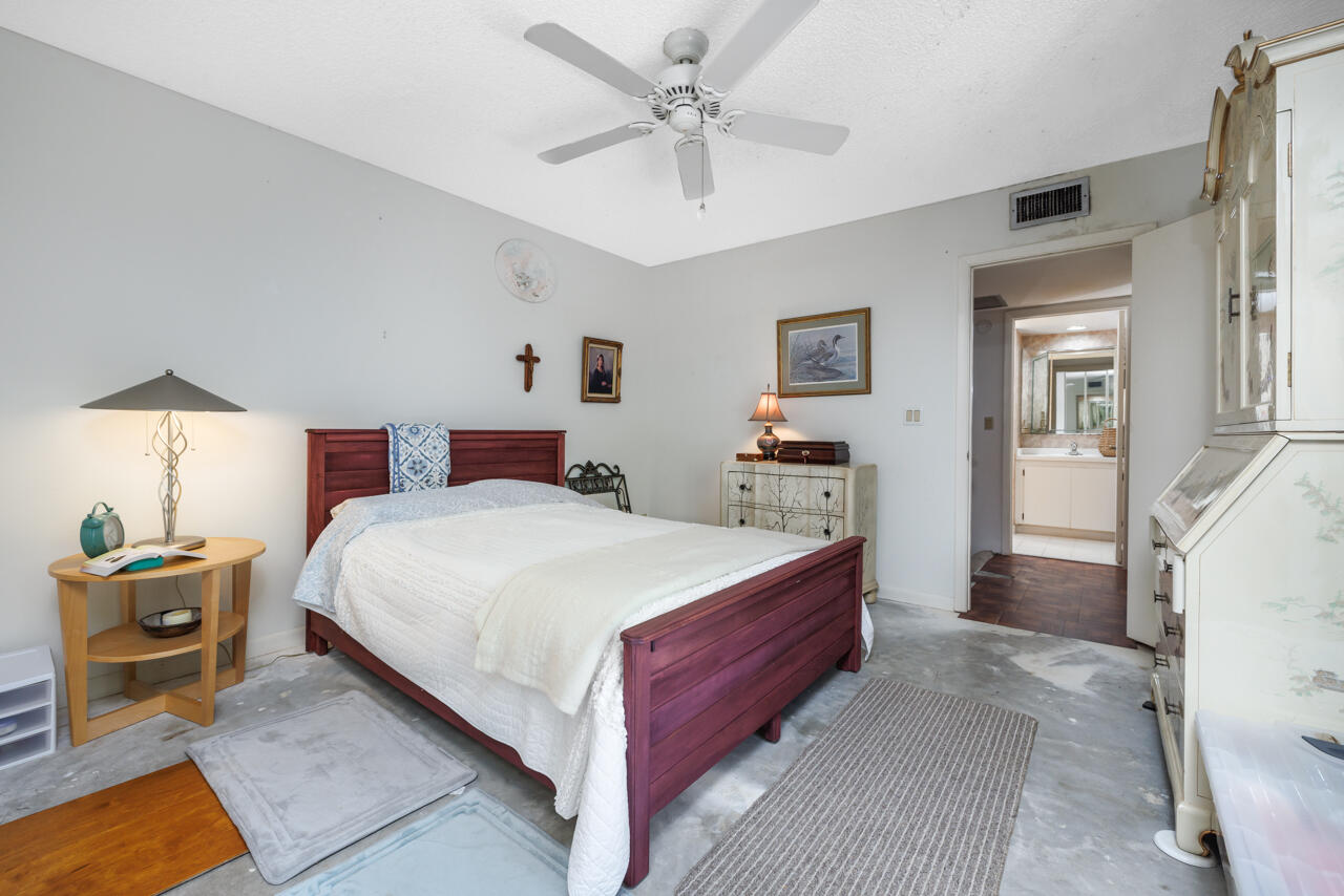 5996 Southeast Riverboat Drive, Unit 539 Stuart, FL 34997 - Photo 17 of 29 a bedroom with a bed and a chandelier
