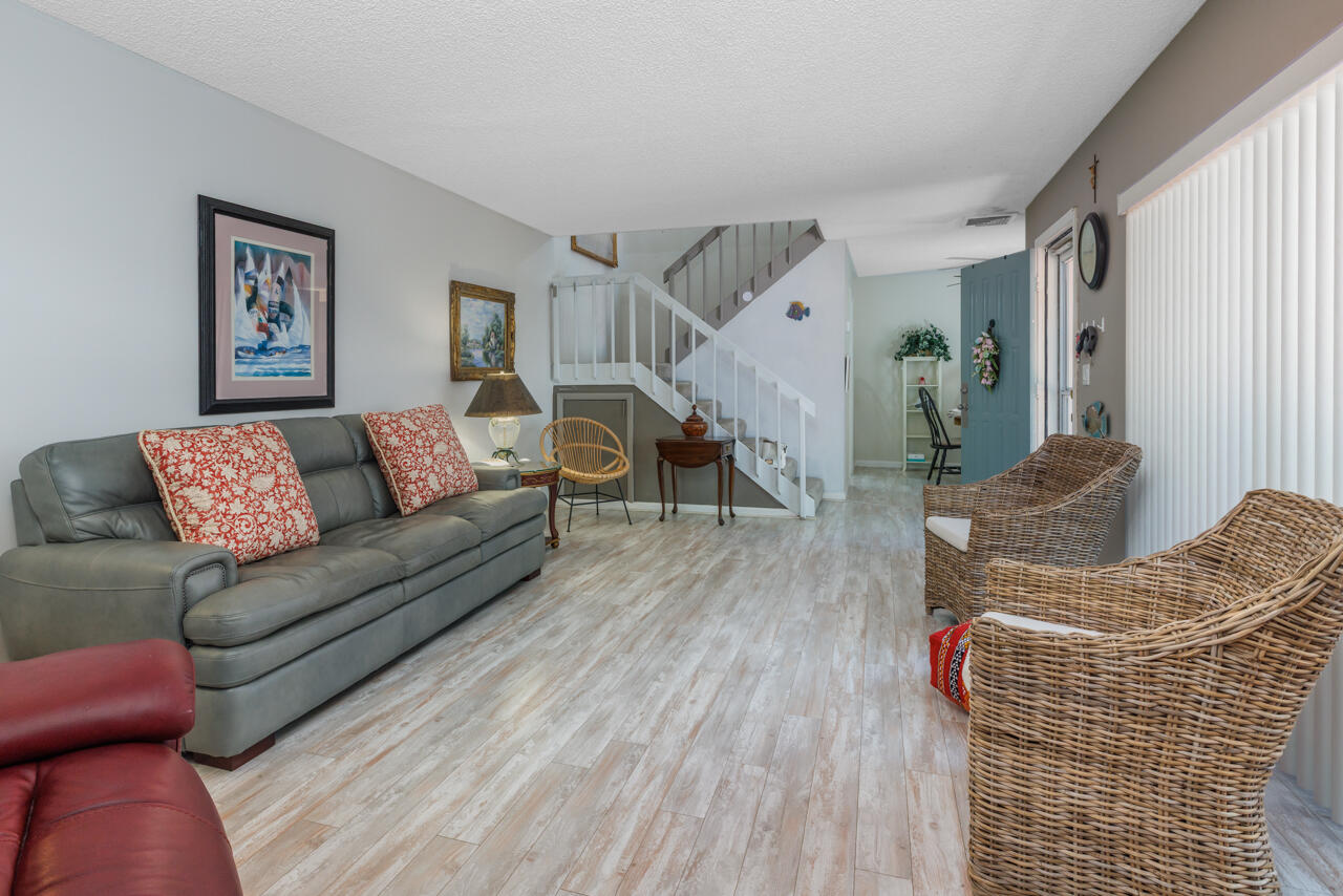 5996 Southeast Riverboat Drive, Unit 539 Stuart, FL 34997 - Photo 7 of 29 a living room with furniture and wooden floor