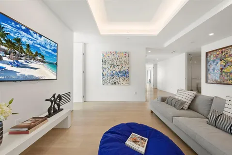 a large white bed sitting in a bedroom next to a window