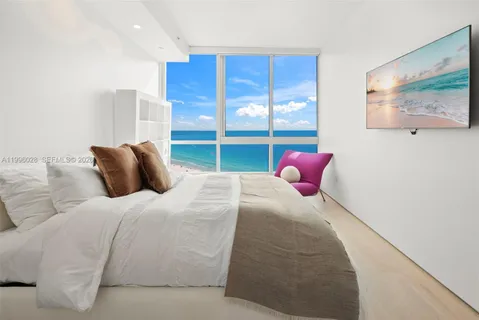 a spacious bedroom with a bed and a flat screen tv