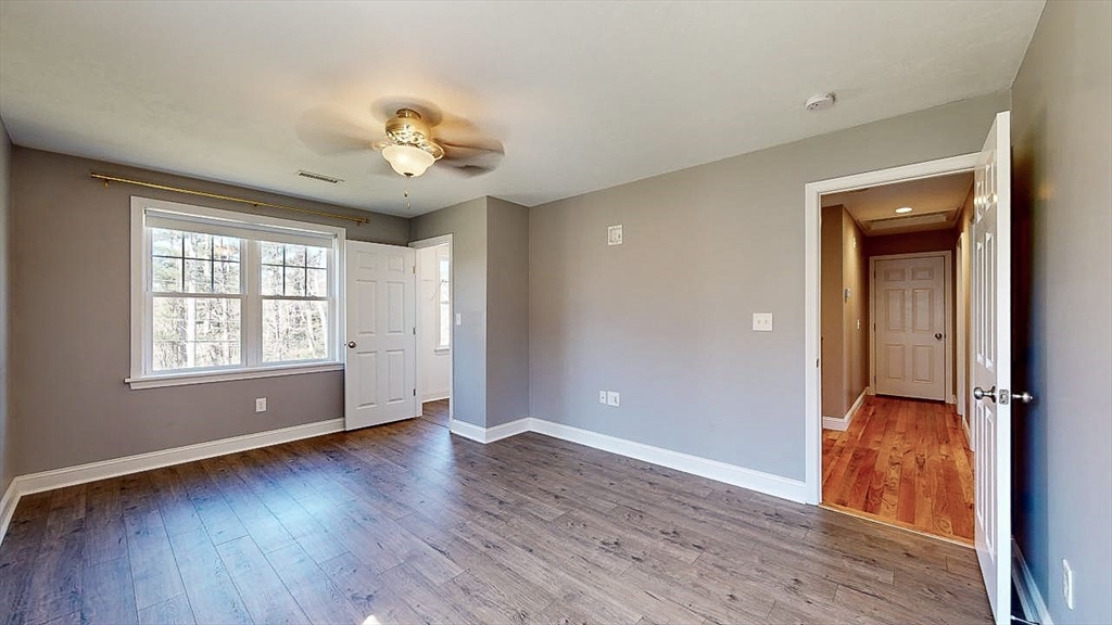577 Podunk Road East Brookfield, MA 01515 - Photo 18 of 42 an empty room with wooden floor chandelier and windows