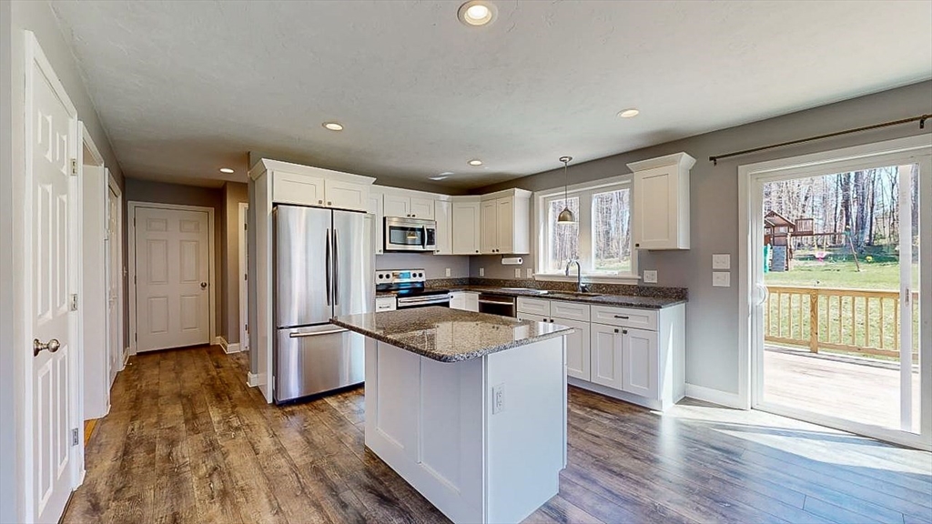 577 Podunk Road East Brookfield, MA 01515 - Photo 2 of 42 a kitchen with stainless steel appliances granite countertop a refrigerator a sink dishwasher a stove and white countertops with wooden floor