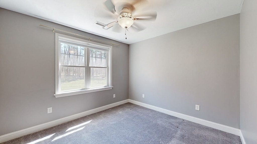 577 Podunk Road East Brookfield, MA 01515 - Photo 27 of 42 an empty room with windows and ceiling fan
