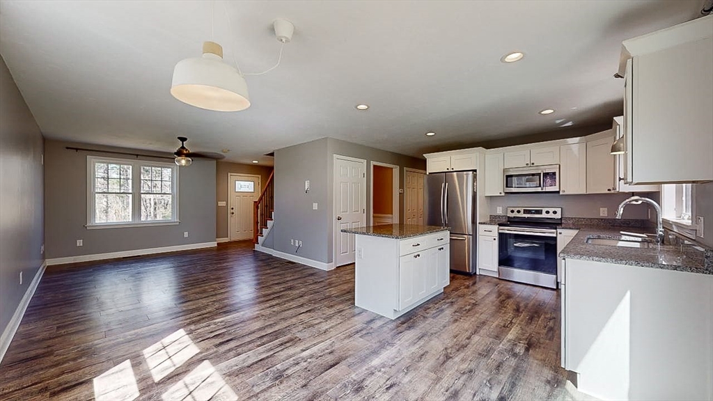 577 Podunk Road East Brookfield, MA 01515 - Photo 9 of 42 a kitchen with stainless steel appliances granite countertop a refrigerator a stove top oven a sink dishwasher and wooden floor