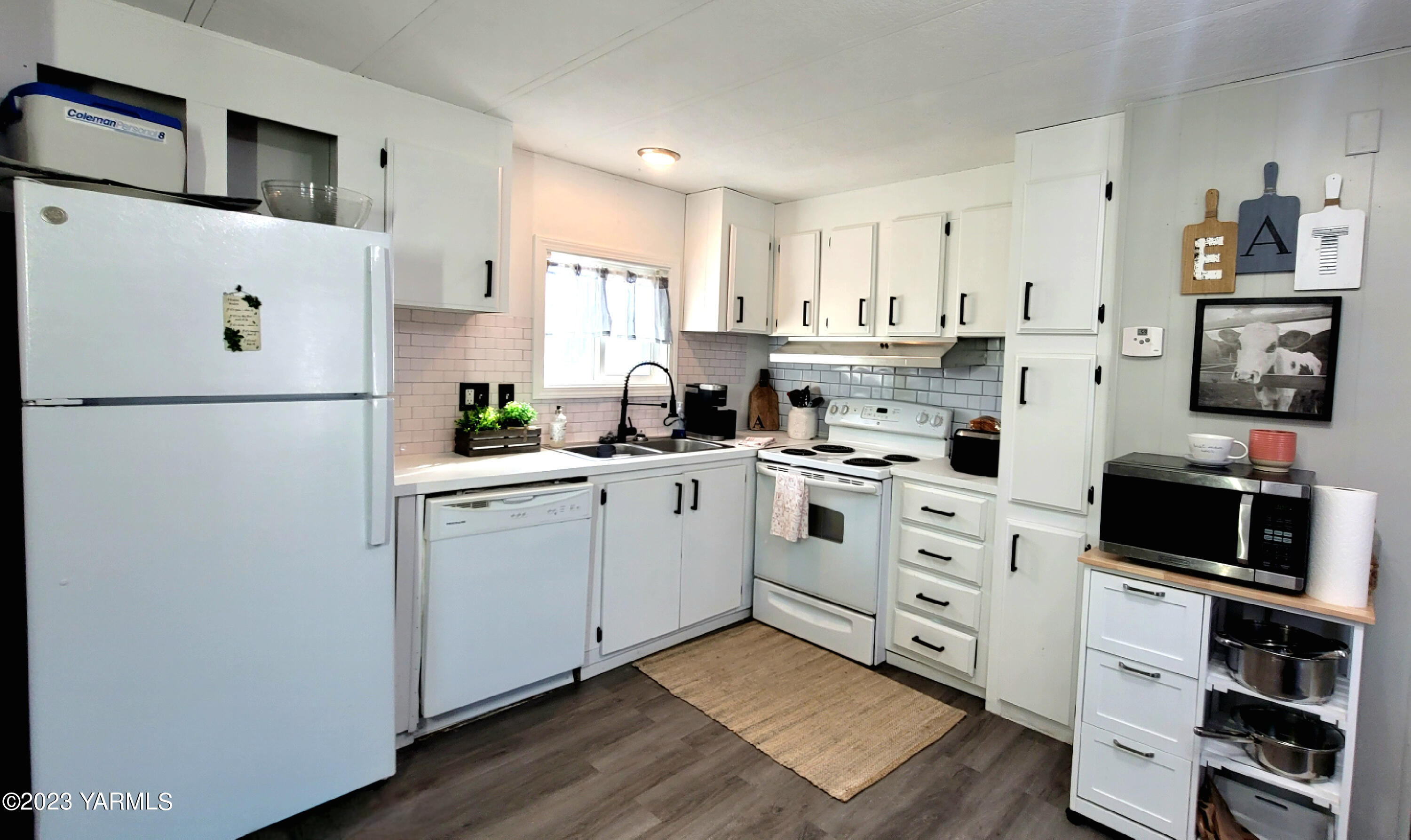 3005 Castlevale Road, Unit 26 Yakima, WA 98902 - Photo 5 of 12 a kitchen with cabinets stainless steel appliances and wooden floor