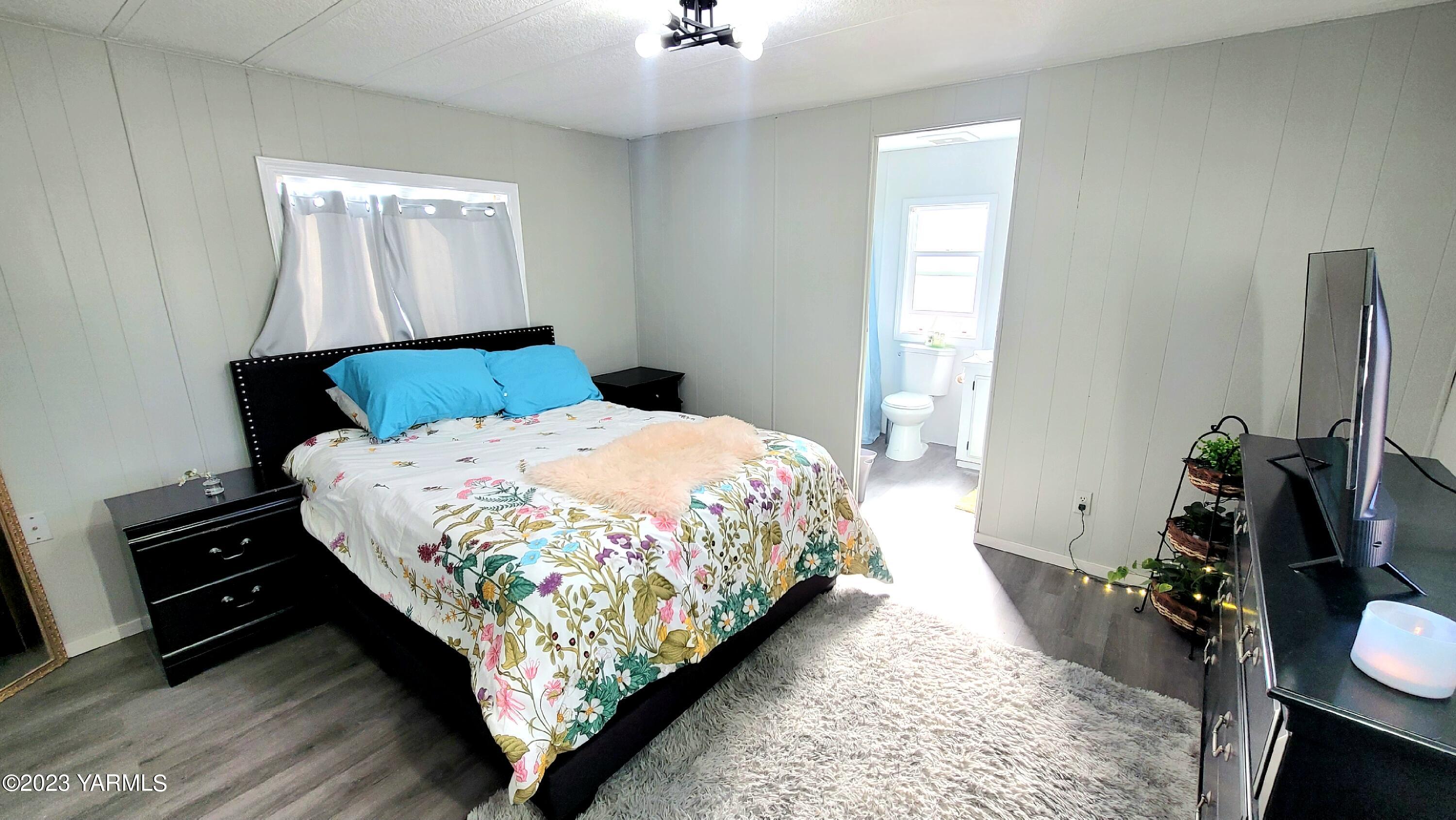 3005 Castlevale Road, Unit 26 Yakima, WA 98902 - Photo 6 of 12 a bed sitting in a bedroom next to a window with potted plants
