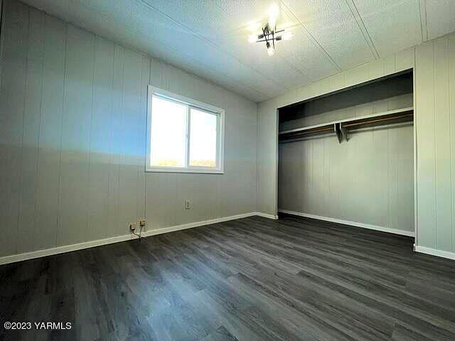 3005 Castlevale Road, Unit 26 Yakima, WA 98902 - Photo 10 of 12 an empty room with wooden floor and windows