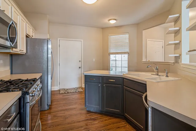 a kitchen with a sink stove top oven and cabinets