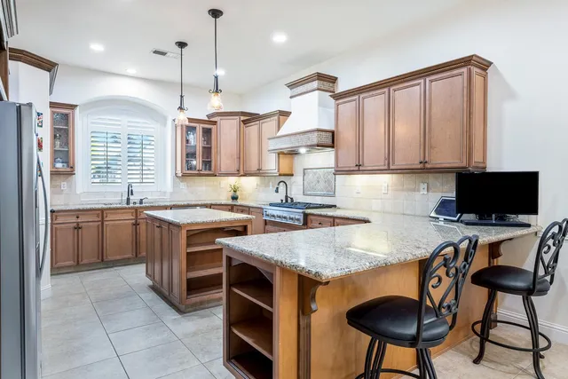 a kitchen with stainless steel appliances granite countertop a stove a sink and a refrigerator
