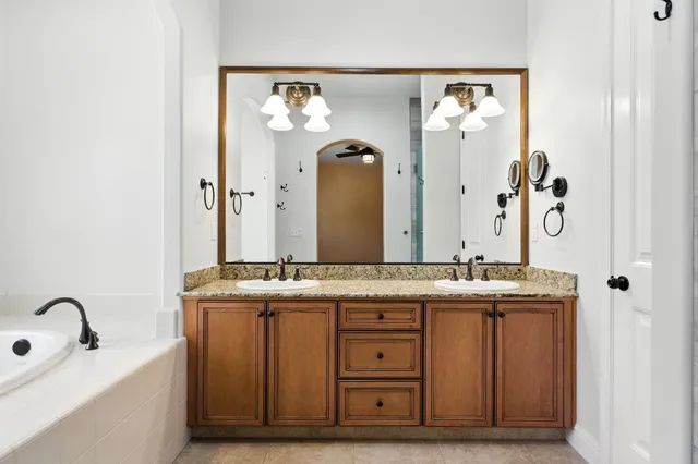 a bathroom with a granite countertop sink vanity and mirror