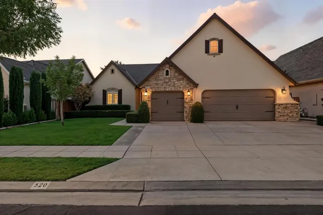 a view of a house with a yard and large tree