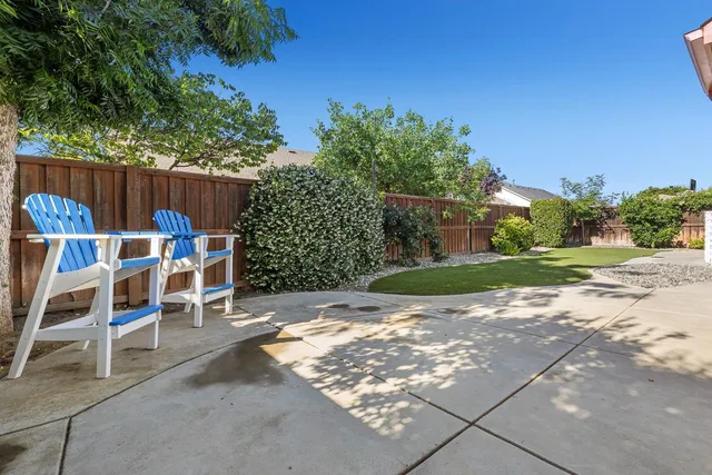 a backyard of a house with table and chairs