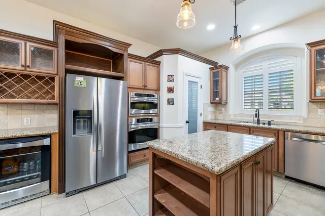 a kitchen with stainless steel appliances granite countertop a refrigerator a oven and a stove