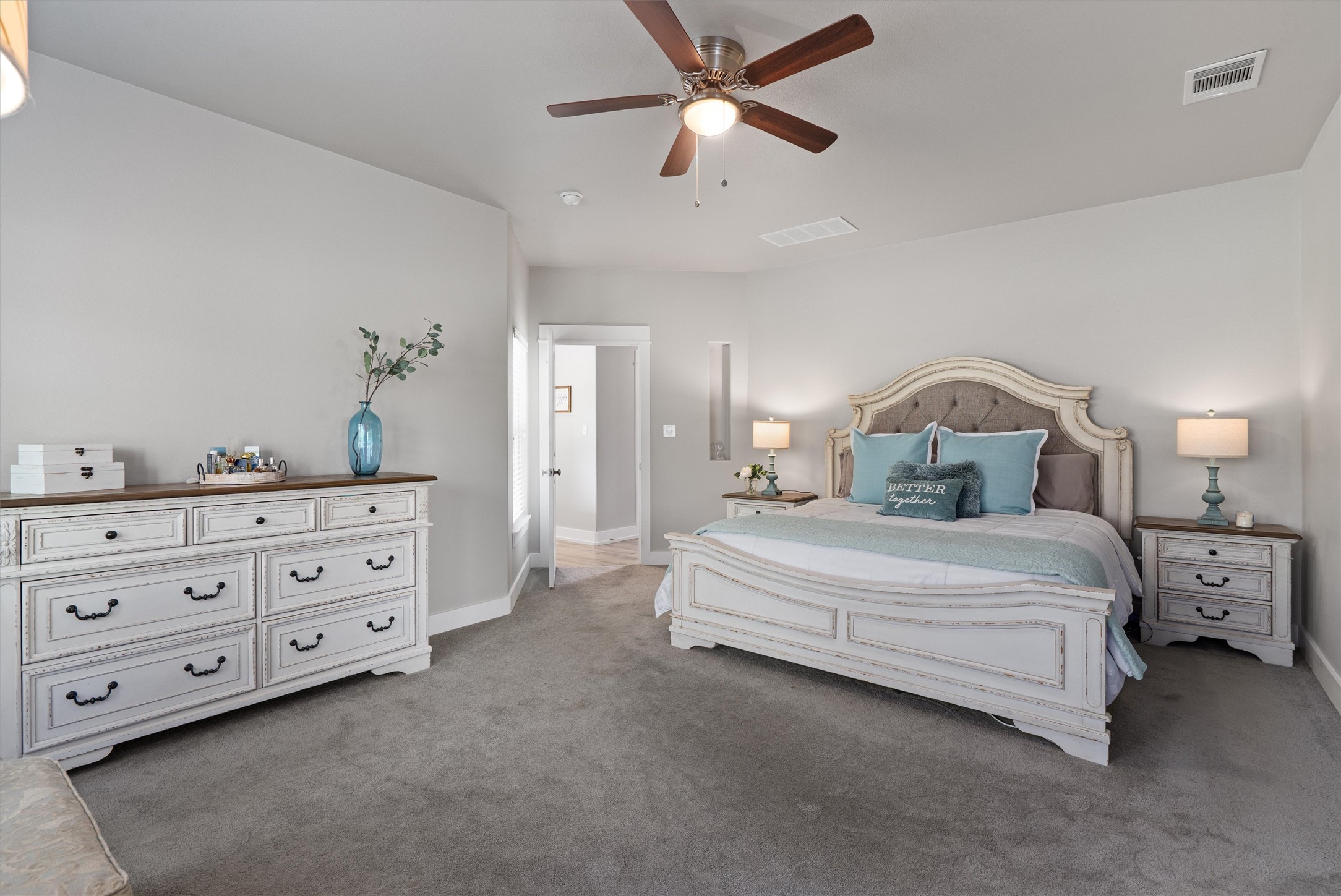 13105 Rooster Springs Road Austin, TX 78737 - Photo 10 of 38 This bedroom features plush grey carpeting, light-colored walls, and a ceiling fan with light fixture