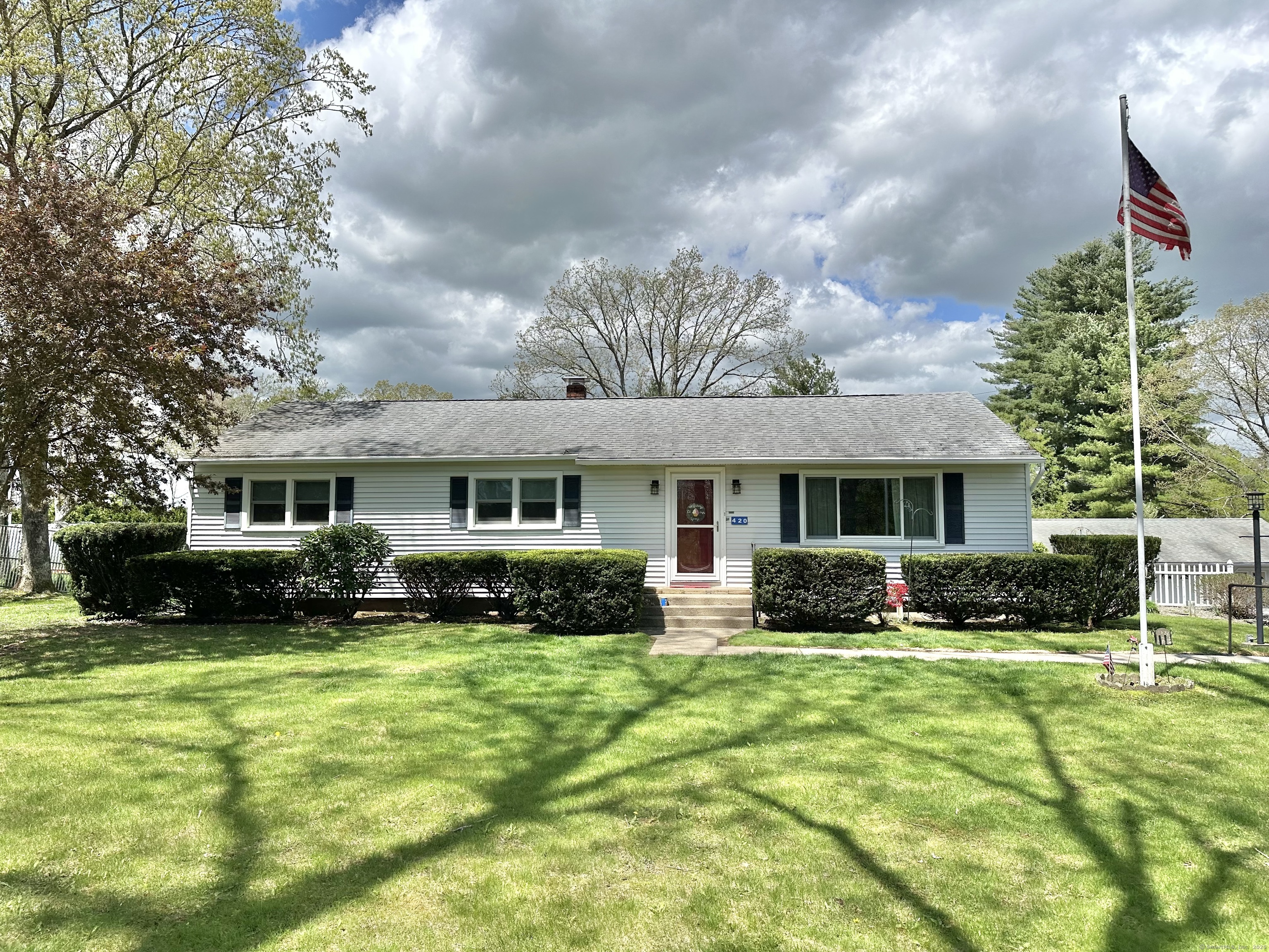 a front view of a house with a yard and trees