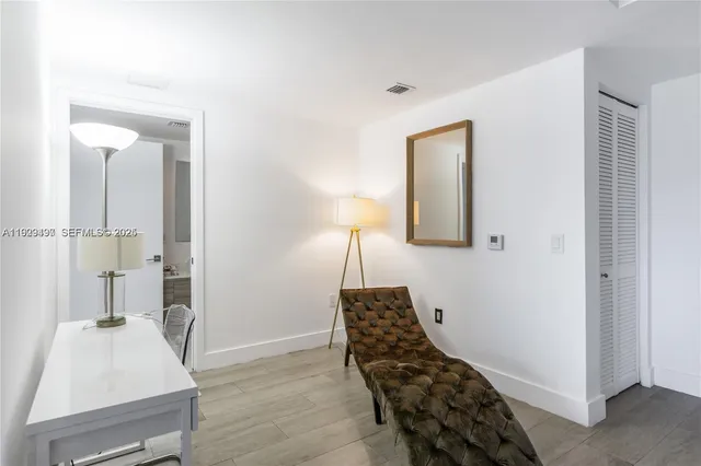 a bedroom with a bed and a lamp on dresser