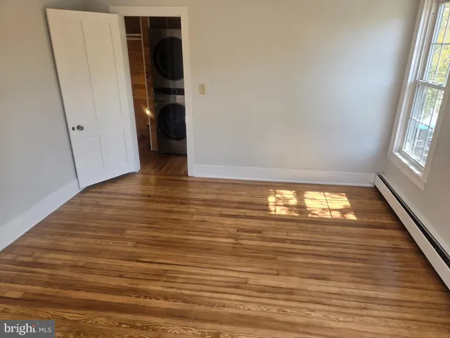 an empty room with wooden floor and entrance