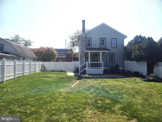 a view of house with backyard and outdoor seating