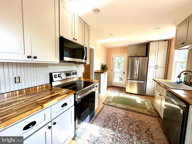 a kitchen with stainless steel appliances kitchen island granite countertop a stove a sink and a microwave