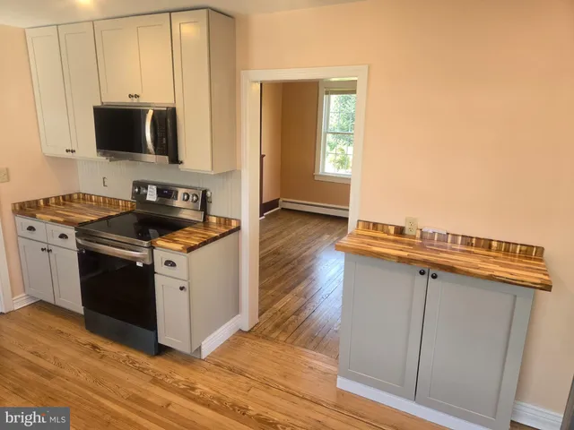 a kitchen with a sink a refrigerator and wooden floor