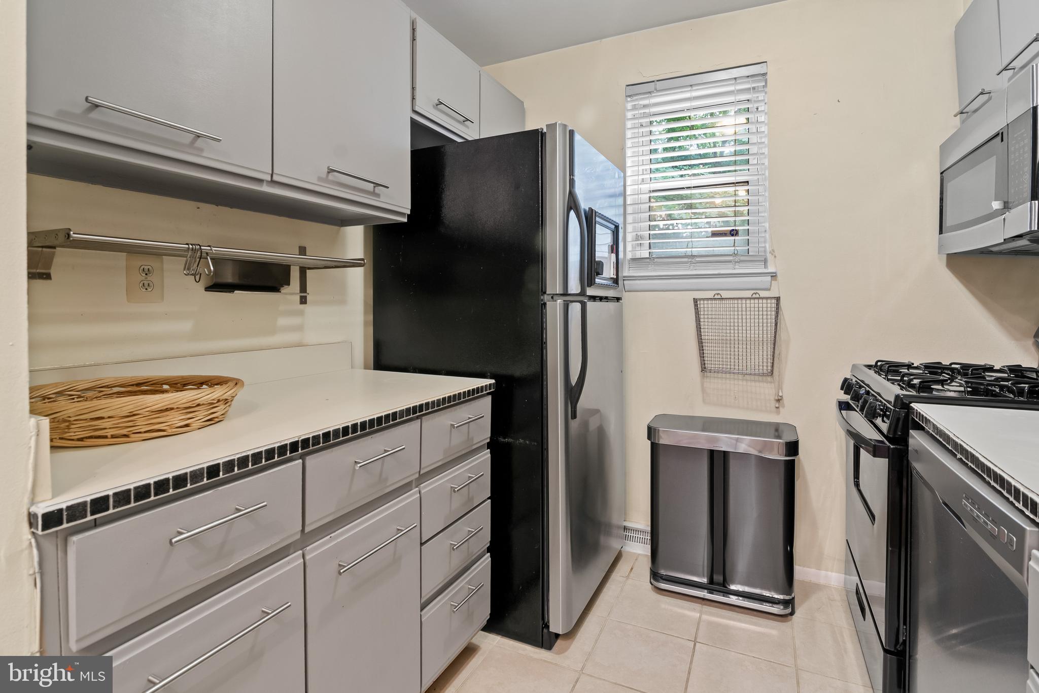 4415 Falls Bridge Drive, Unit K Baltimore, MD 21211 - Photo 11 of 18 a kitchen with a refrigerator stove and cabinets