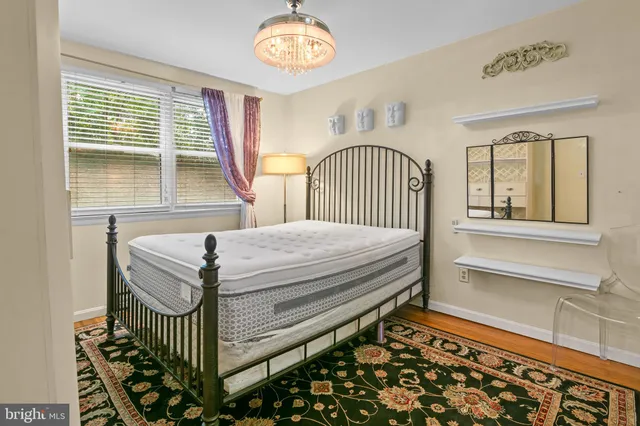 a bed sitting in a bedroom next to a bathroom sink