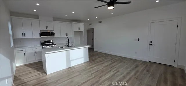 a kitchen with granite countertop a sink cabinets and stainless steel appliances