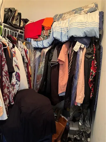 a view of walk in closet with clothes and shoes