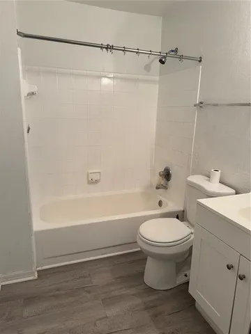 a white toilet sitting next to a bath tub
