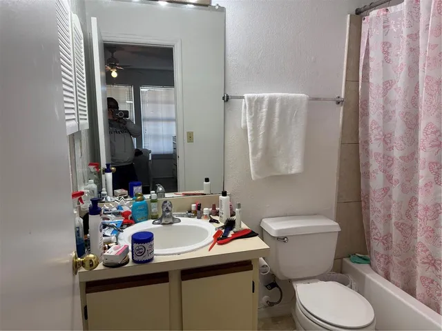 a bathroom with a sink toilet vanity and shower