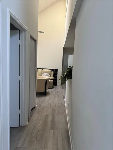 a view of a hallway with wooden floor and staircase