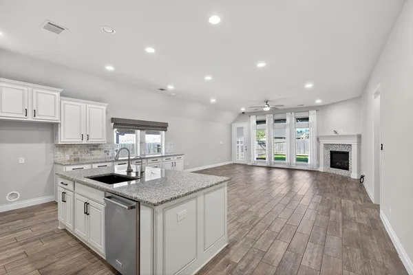 a kitchen with granite countertop a sink and stove top oven