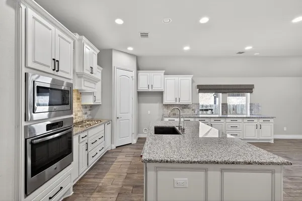 a kitchen with stainless steel appliances granite countertop a sink stove and refrigerator
