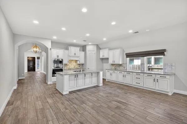 a large kitchen with stainless steel appliances granite countertop a large center island and a stove