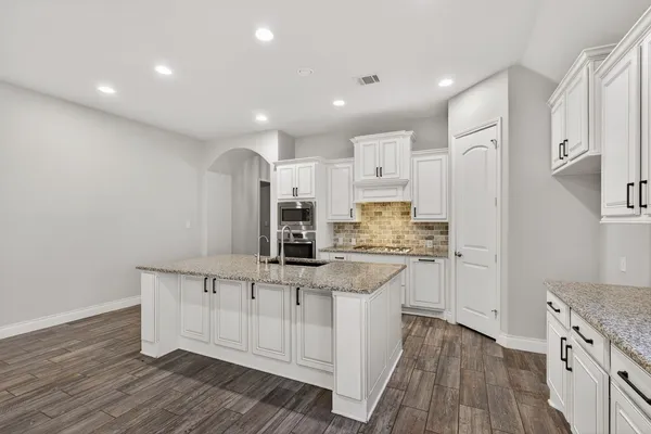 a kitchen with white cabinets and appliances