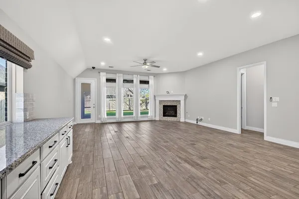 an empty room with wooden floor and fireplace