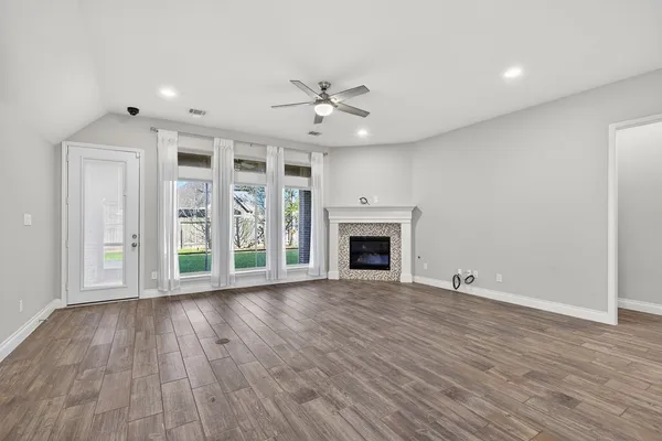 wooden floor fireplace and windows in an empty room