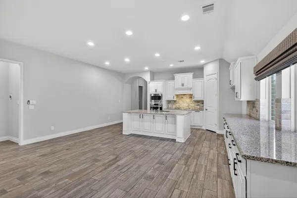 a view of kitchen with kitchen island stainless steel appliances refrigerator stove microwave and cabinets